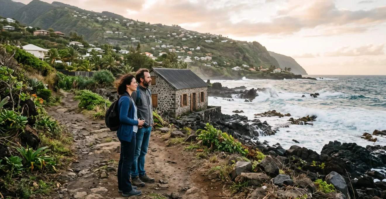 Un couple observe une maison en bord d'océan depuis un sentier côtier à Saint-Pierre.